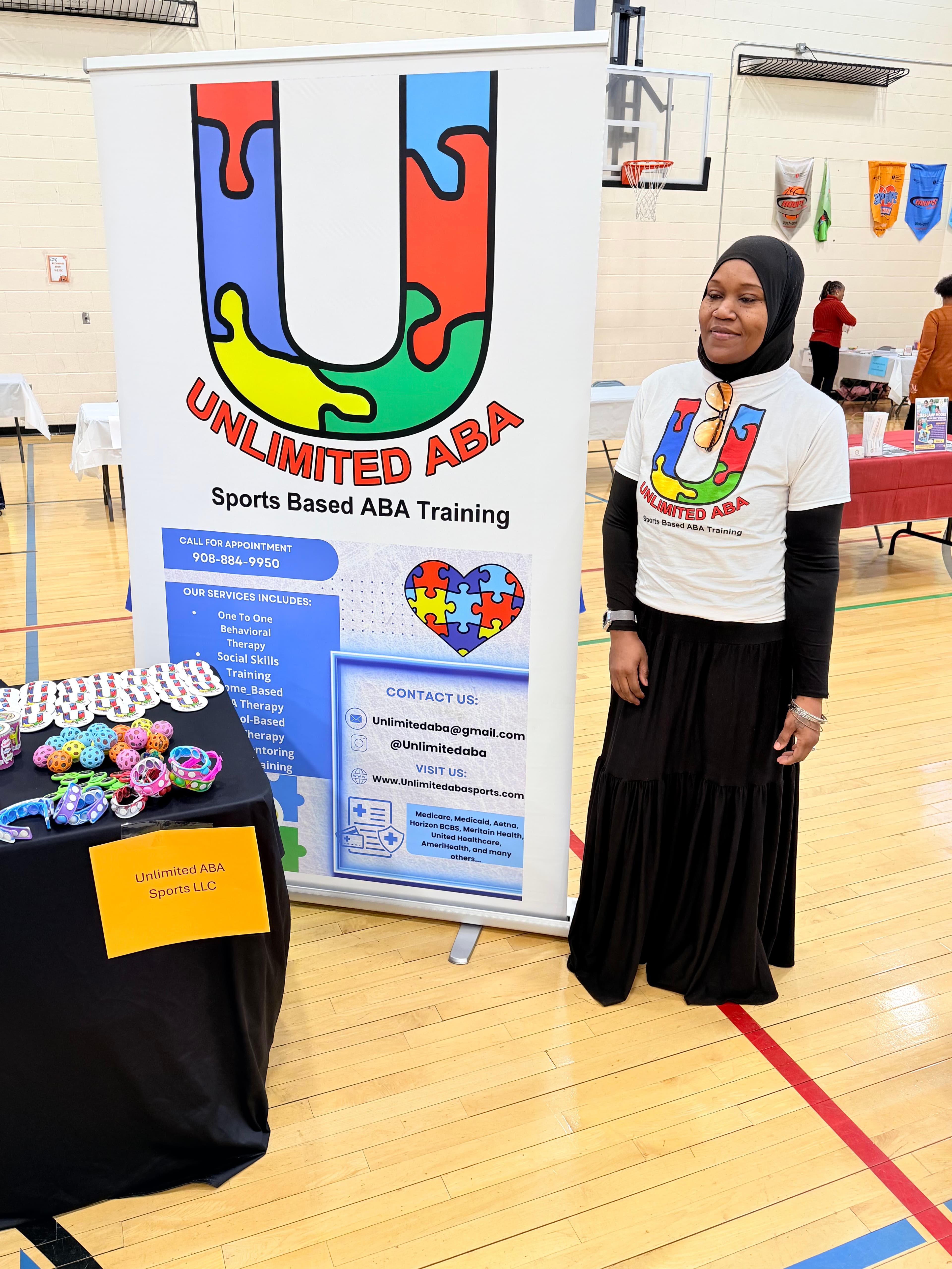 Basim Hudeen standing next to Unlimited ABA banner at event